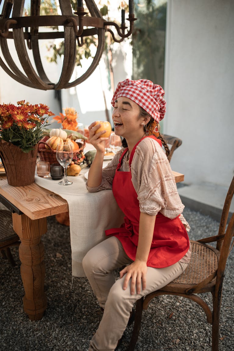 Woman enjoying Thanksgiving dinner outdoors with autumn decor.
